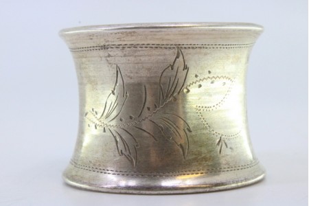 Argola de guardanapo em prata com motivos florais gravados envolvendo cartela para monograma.